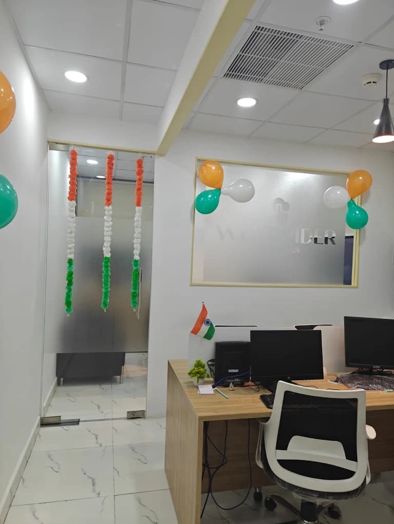 The first Web Spider Solutions office dressed in tricolour: orange, white and green garlands on the frosted glass door, balloons round the logo panel and a small Indian flag on a desk.